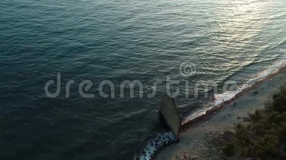 黑海沿岸的孤独岩石名为岩石帆由海浪和海鸥通过电影4k镜头飞行视频的预览图