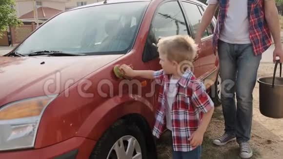 父亲带着一桶水在假期里和儿子慢动作洗了那辆红色的车视频的预览图