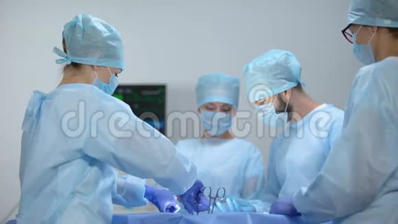 护士在监视器上查看心率外科医生团队进行侵入性操作视频的预览图