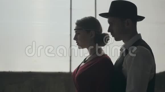 肖像男戴fedora帽子古典西装和女人穿着风格的布在肮脏的地方跳舞废弃的破旧视频的预览图