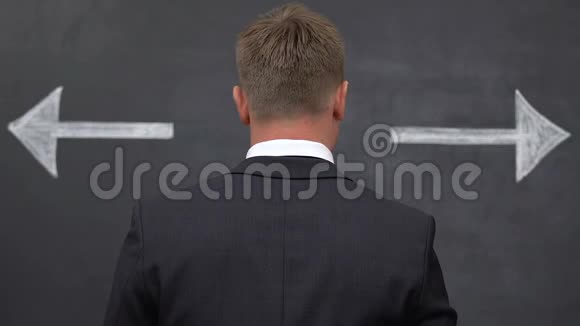 男西装革履选择发展方向黑板上的箭头视频的预览图