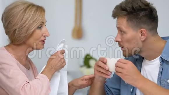 爱看热闹的母亲在喝茶前把餐巾贴在儿子的脖子上过度保护视频的预览图