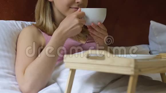 放松的女人在床上喝早茶好日子开始周末时间视频的预览图