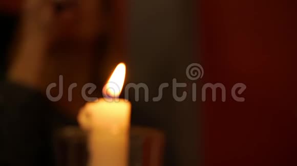 蜡蜡烛焰对抗带酒杯的模糊女人视频的预览图