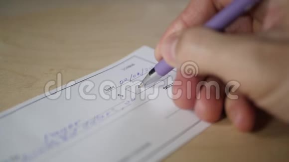 男人用圆珠笔写支票付款视频的预览图