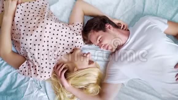上下镜头旋转年轻浪漫情侣面对面躺在床上视频的预览图
