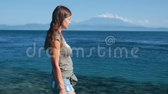 女孩旅行者使用电话类型信息海洋背景山脉缓慢运动视频的预览图