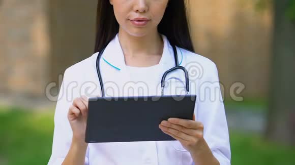 女性治疗师通过平板电脑在线应用程序查看患者的测试结果视频的预览图