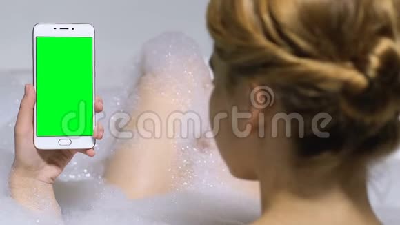 浴缸内女性手持预键手机商务应用视频的预览图