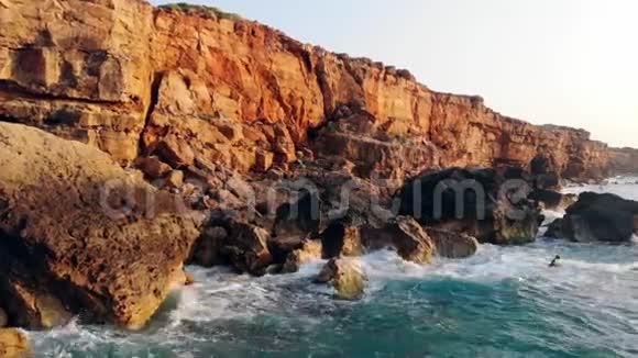 在日落的背景下海洋波浪Neasr岩石海洋海岸野生自然概念视频的预览图