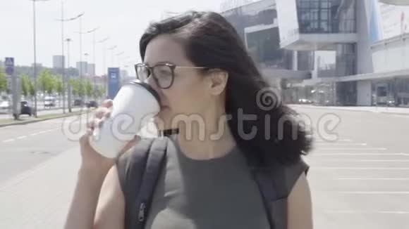 在城市户外喝咖啡的年轻女子视频的预览图