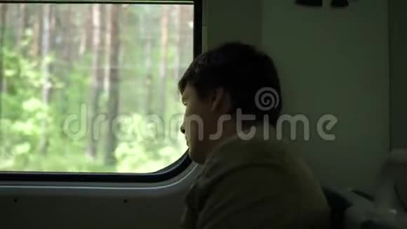 那家伙坐着火车看着窗外看着窗外移动的物体与家人一起旅行视频的预览图