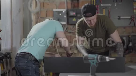 两个人在一个带工具的小作坊里工作两个木工用她的工具制作木片手的概念视频的预览图