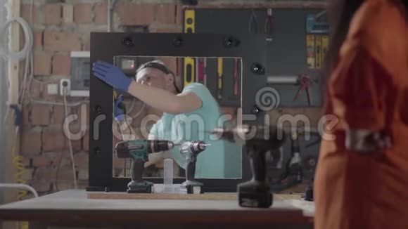家具厂的女工人测试钻头螺丝刀手上有纹身的女人在视频的预览图