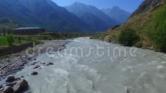 沿着一条暴风雨的山河飞行俯瞰高加索山脉4K视频的预览图