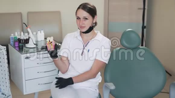 可爱的女性牙医展示了龋齿和健康牙齿的模型慢动作视频的预览图