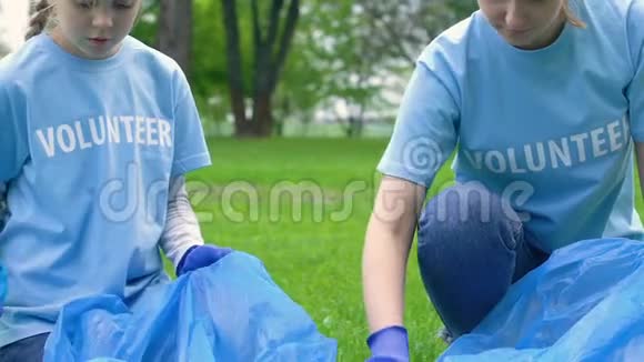 城市公园社会生态活动中收集垃圾的妇女和女童志愿者视频的预览图
