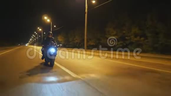 戴着头盔的年轻人骑着现代运动摩托车在傍晚的城市街道骑摩托车的摩托车视频的预览图