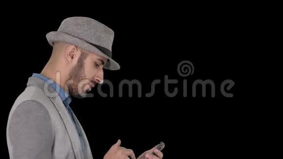 严肃的阿拉伯休闲男子在行走时使用智能手机阿尔法频道视频的预览图