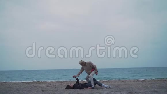 一对夫妇躺在海边的沙滩上视频的预览图