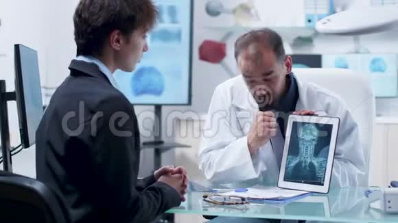 男医生给一位年轻的女性病人看了一张X光片视频的预览图