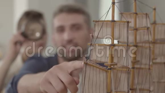 可爱的孩子手里拿着百叶窗看着它的细节玩具父亲和他的儿子在玩船视频的预览图