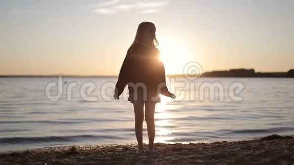 阳光明媚的女学生在日落时在湖边跳舞视频的预览图