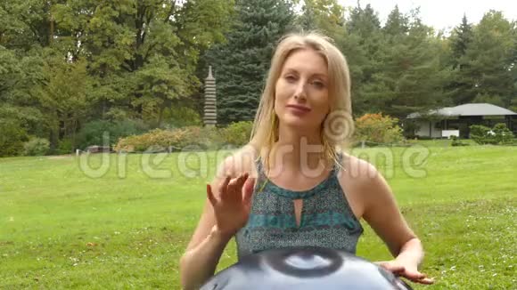 迷人的金发女郎在草坪上玩吊视频的预览图