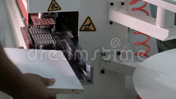 男人的手在设备中放置一个木制的部分来粘合边缘特写镜头边缘刨花板零件机视频的预览图