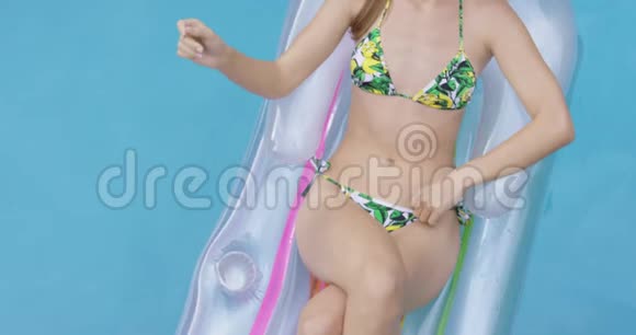 女性放松双手后头放在4k游泳池的充气管上视频的预览图