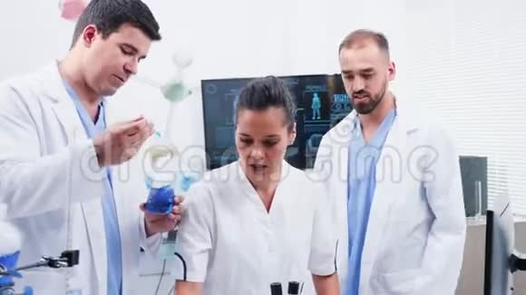 现代实验室的化学家在用蓝色的吸烟液体视频的预览图