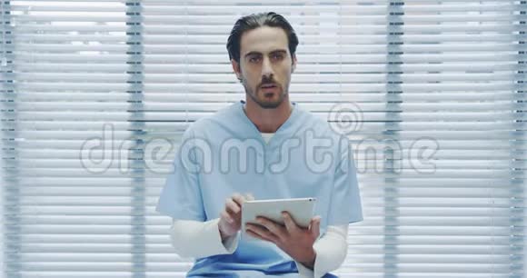 年轻的男医生用平板电脑和摄像机通话视频的预览图