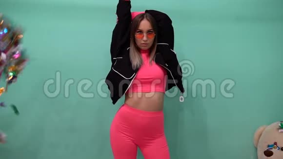 纸屑在一个穿着粉红色衣服的时髦女孩面前飞舞视频的预览图