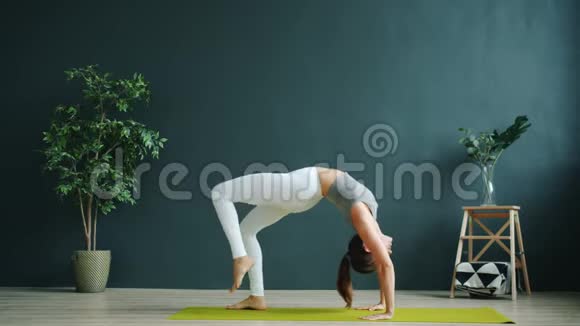 在现代健康中心独自锻炼瑜伽的学生做Chakrasana视频的预览图