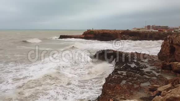 海水在岩石上破裂强烈的泡沫海浪在岛上的岩石海岸翻滚视频的预览图