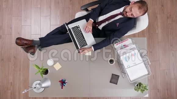 西装革履的年轻商人站在办公桌上的俯视图视频的预览图