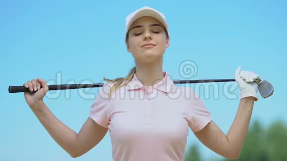 女子高尔夫球手弯曲两侧肩膀上的棍棒使背部肌肉变暖视频的预览图