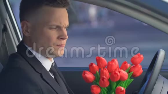 年轻人在车里扔花和女友分手后很沮丧视频的预览图