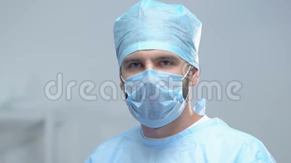 专业外科医生看着摄像机摘下防护面罩拯救生命视频的预览图