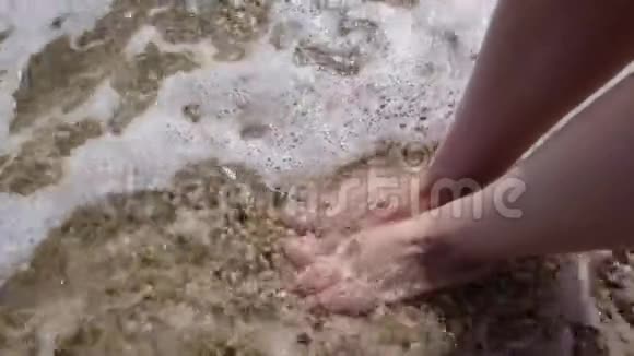 海水冲刷沙滩上的女性腿视频的预览图