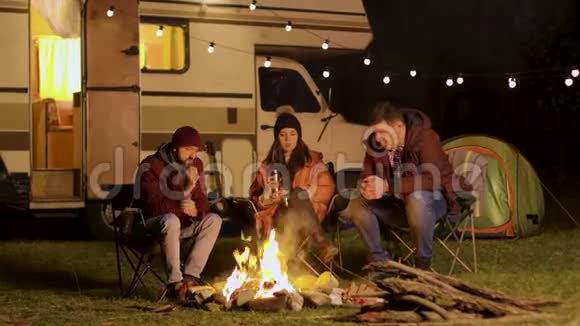 一群朋友在寒冷的秋夜聚集在篝火旁视频的预览图