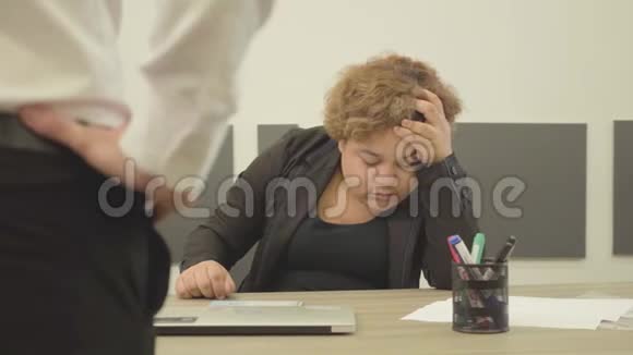 那个丰满疲惫的女人坐在办公室的桌子旁睡觉一个面目全非的老板来到办公桌前视频的预览图