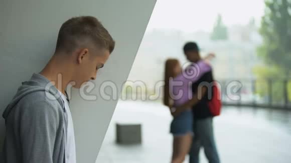 愤怒的男学生看着女朋友拥抱男人爱失望视频的预览图