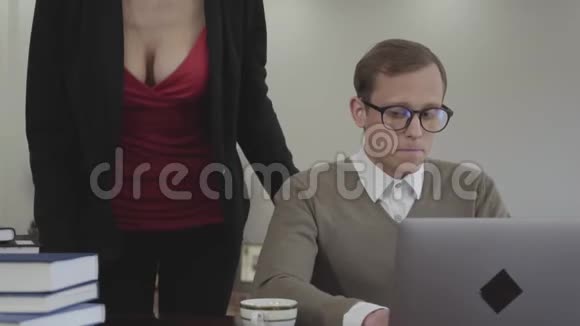 肖像年轻可爱谦虚戴眼镜的男人坐在家里的桌子上在笔记本电脑上工作美丽的女人视频的预览图
