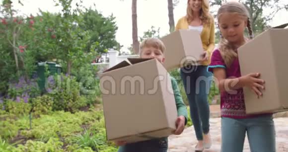 母亲和孩子带着纸板箱回家视频的预览图
