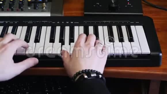 手在音乐工作室的钢琴MIDI键盘上演奏音乐创作过程流行音乐流行作曲家为音乐专辑创作新歌曲视频的预览图