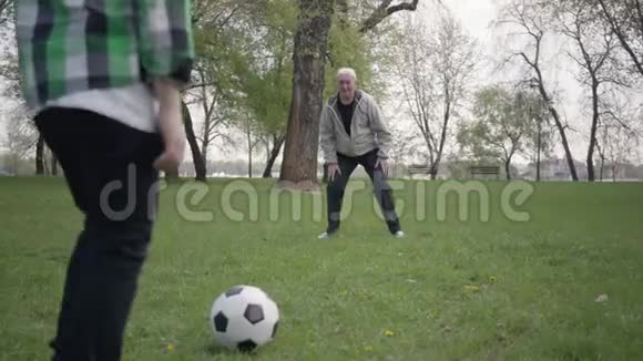 孙子击球爷爷接球家庭在户外玩得开心生活方式活跃世代概念视频的预览图