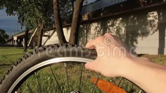 一只手握着一个放气的自行车轮穿孔自行车视频的预览图