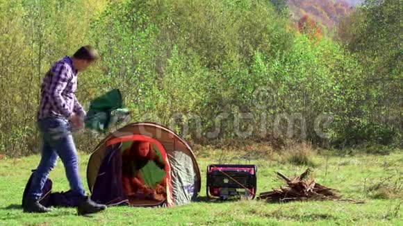 女朋友准备帐篷的时候男朋友坐在野营座位上视频的预览图