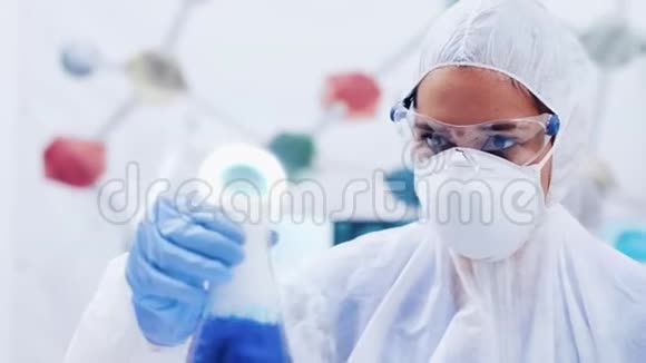女科学家用蓝色液体摇动瓶子视频的预览图